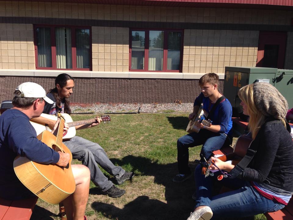 A picture of students playing guitars outside at BMCC.